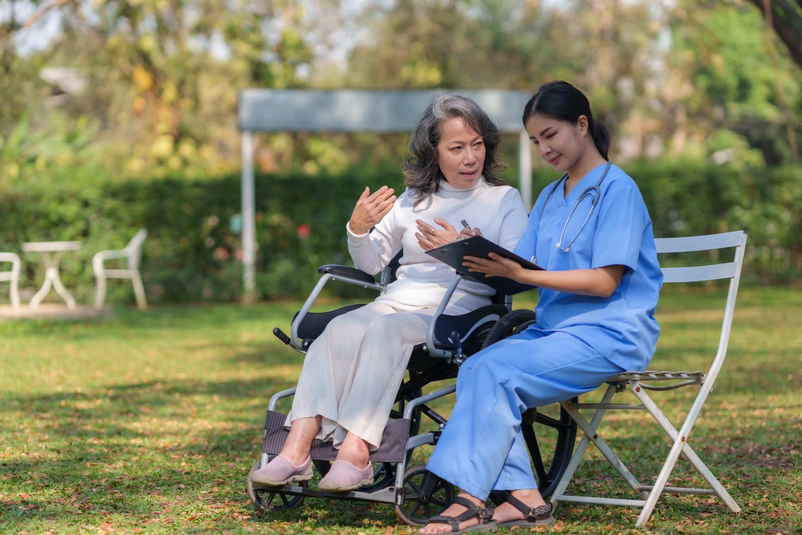 "Asian healthcare professional assisting elderly patient"