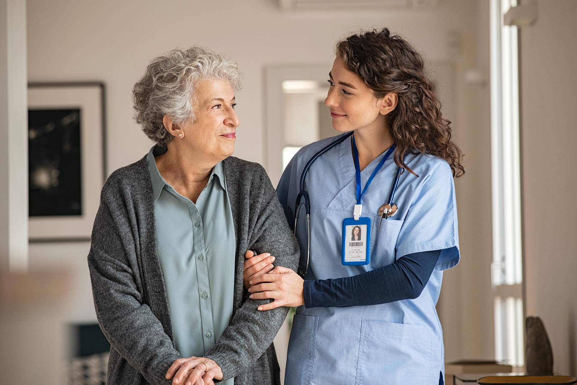 Caregiver assisting senior woman with daily activities at home