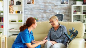 Female nurse engaging with elderly Alzheimer's patient at home